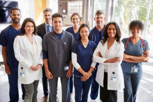 Team of healthcare workers at a hospital smiling to camera